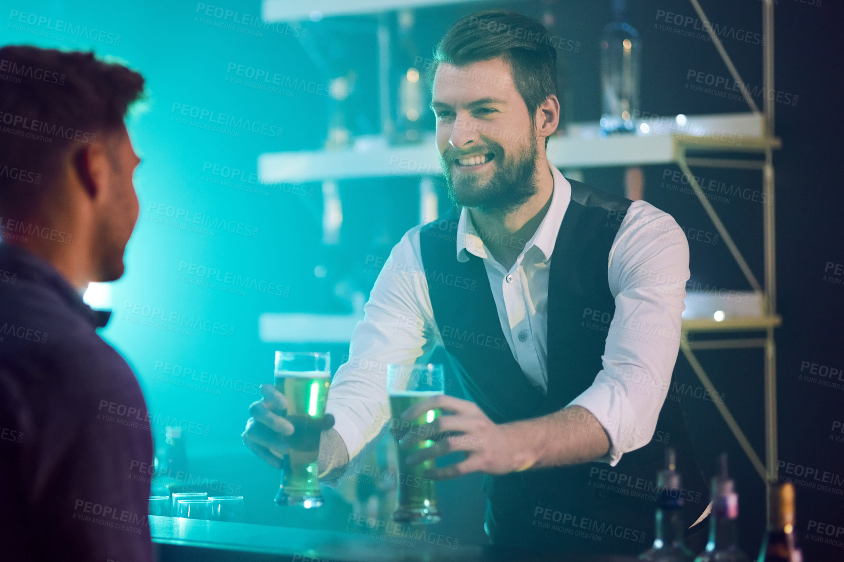 Buy stock photo Cropped shot of a bartender serving drinks to a man in a nightclub