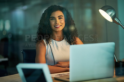 Buy stock photo Portrait of a confident young businesswoman working at her desk at night