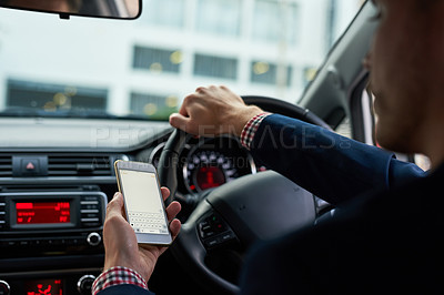 Buy stock photo Cropped shot of an unrecognizable businessman using his cellphone while driving
