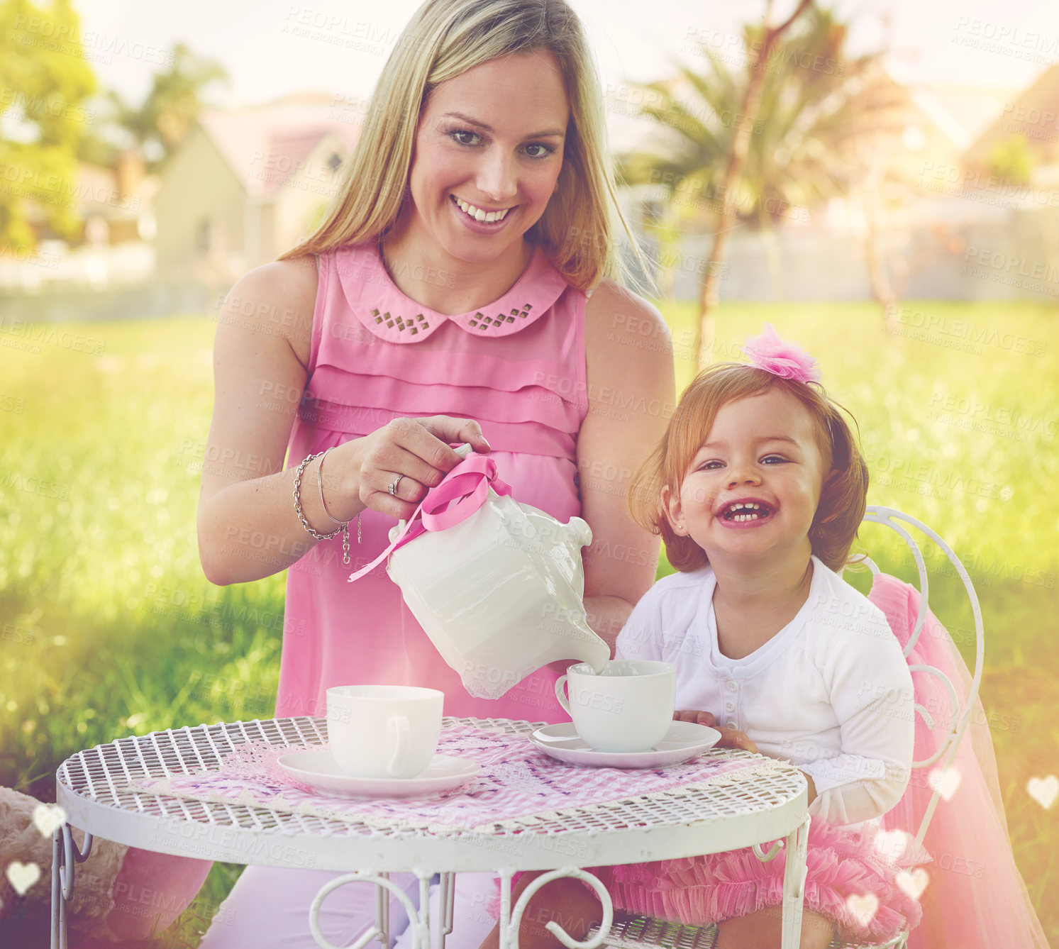 Buy stock photo Portrait of a mother and her cute little girl having a tea party on the lawn outside