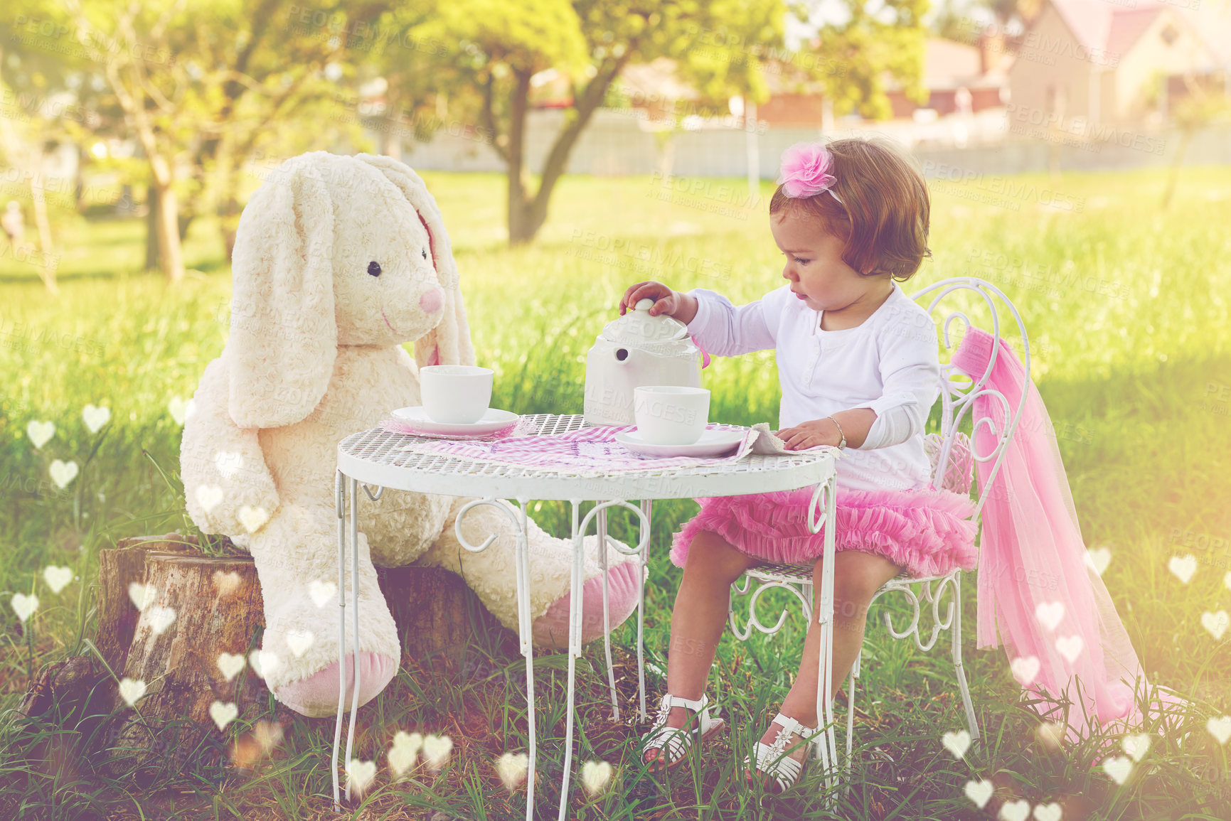 Buy stock photo Shot of a cute little girl having a tea party with her stuffed animal on the lawn outside