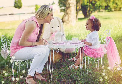 Buy stock photo Shot of a mother and her cute little girl having a tea party on the lawn outside