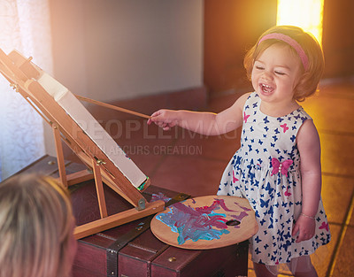 Buy stock photo Shot of an adorable little girl painting a picture while her mother watches at home