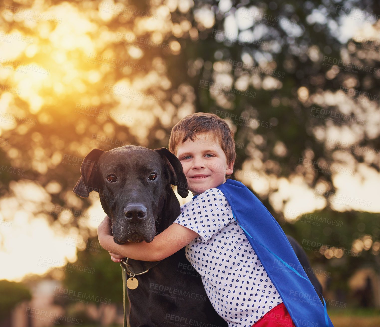 Buy stock photo Shot of a little boy and his dog wearing capes while playing outside