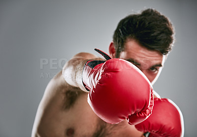 Buy stock photo Studio portrait of a young man boxing against a gray background