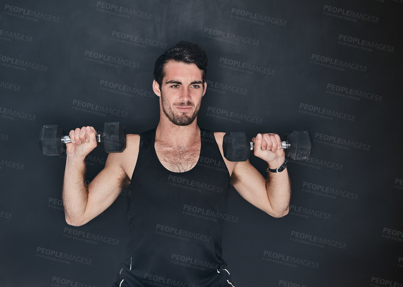 Buy stock photo Studio shot of a young man working out with a dumbbell against a gray background