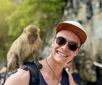 Buy stock photo Portrait of a young man with a monkey sitting on his shoulder outside