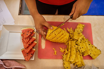 Buy stock photo Shot of an unidentifiable chef's hands as she cuts fruit in the kitchen