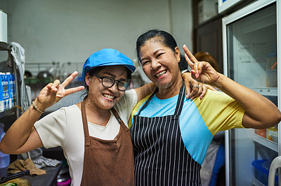 Buy stock photo Portrait of two happy cooks posing together in the kitchen