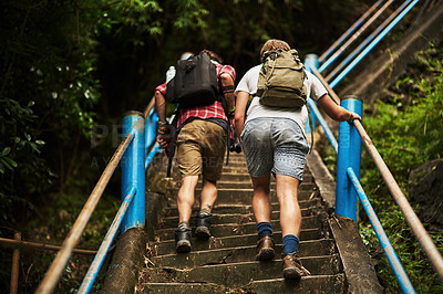 Buy stock photo Rearview shot of two men climbing stairs while hiking in the mountains