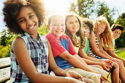 Buy stock photo Portrait, outdoor and children in park, sunshine and diversity with fun, summer and weekend break. Face, group and kids on bench, nature or bonding together with friends, playful or vacation with joy