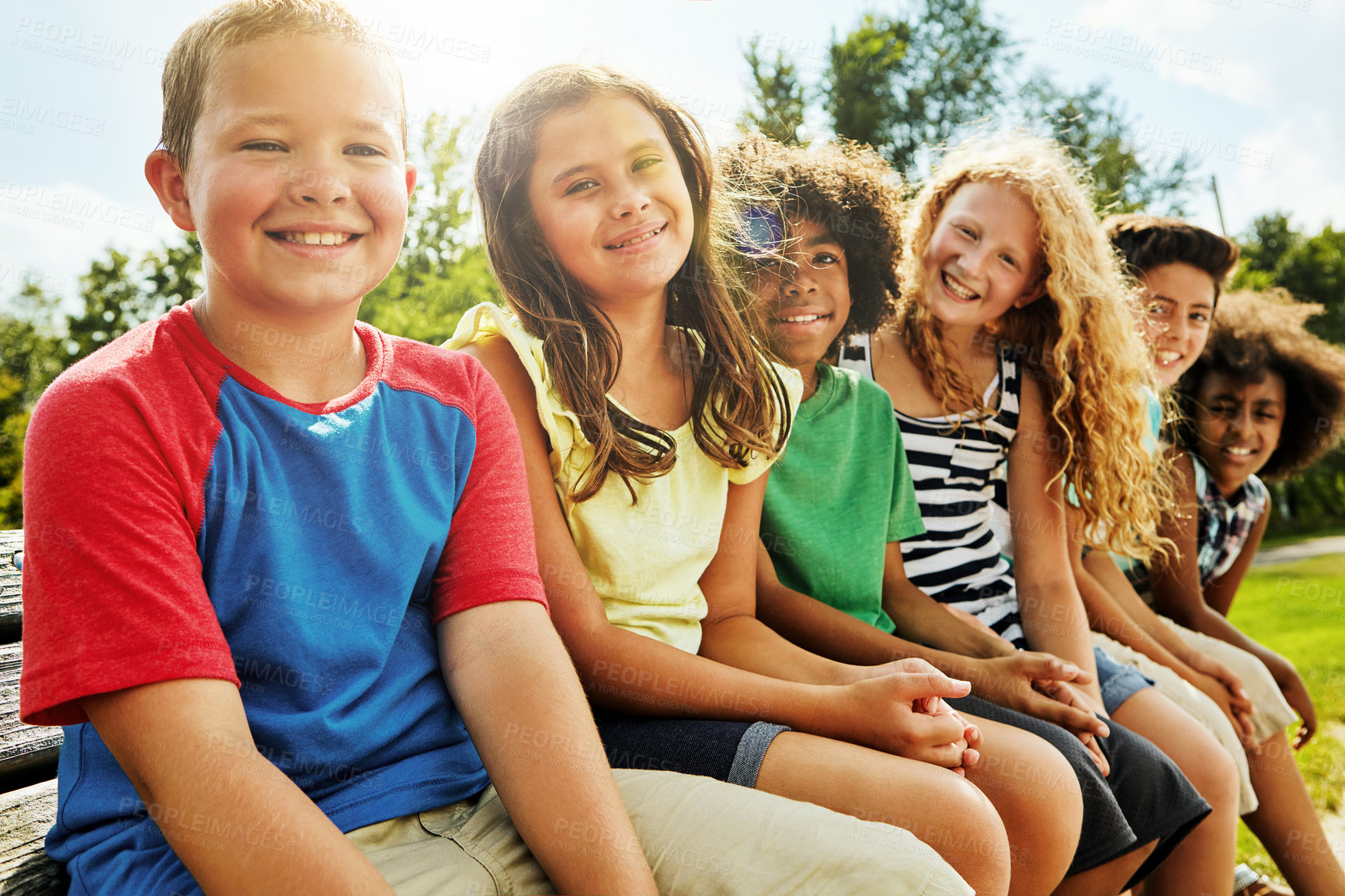 Buy stock photo Portrait, park and children on bench, smile and diversity with nature, sunshine and weekend break. Face, group and kids with summer, fun or bonding together with friends, playful and holiday with joy