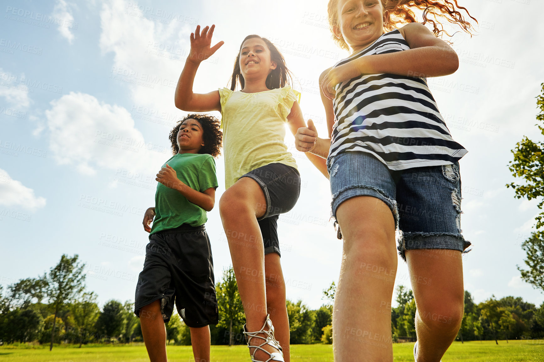 Buy stock photo Happy girl, summer and running with friends in nature for fun, playful day or sunshine at park. Diverse group of excited kids, children or youth enjoying sunny outdoor holiday on grass field together