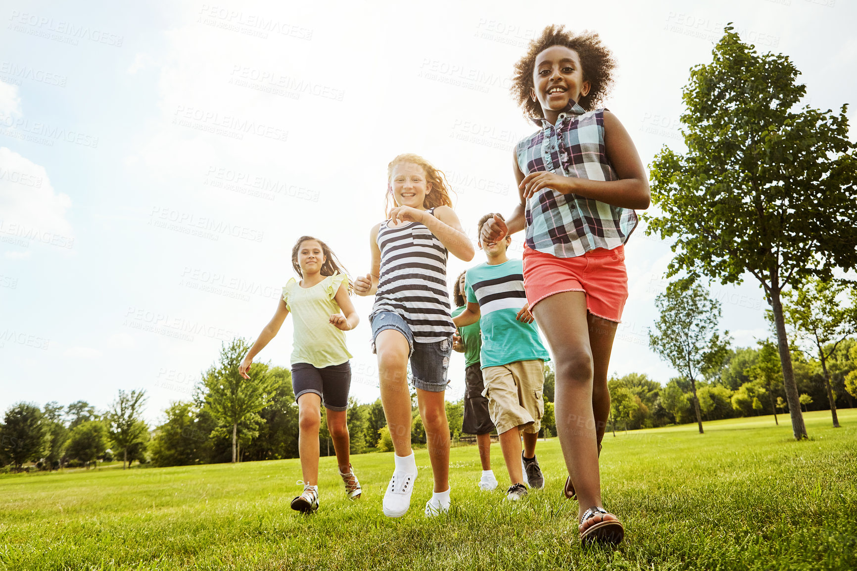 Buy stock photo Happy friends, diversity and running with kids in nature for fun, playful day or summer at park. Group of excited children or youth enjoying sunny outdoor holiday or weekend on grass field together