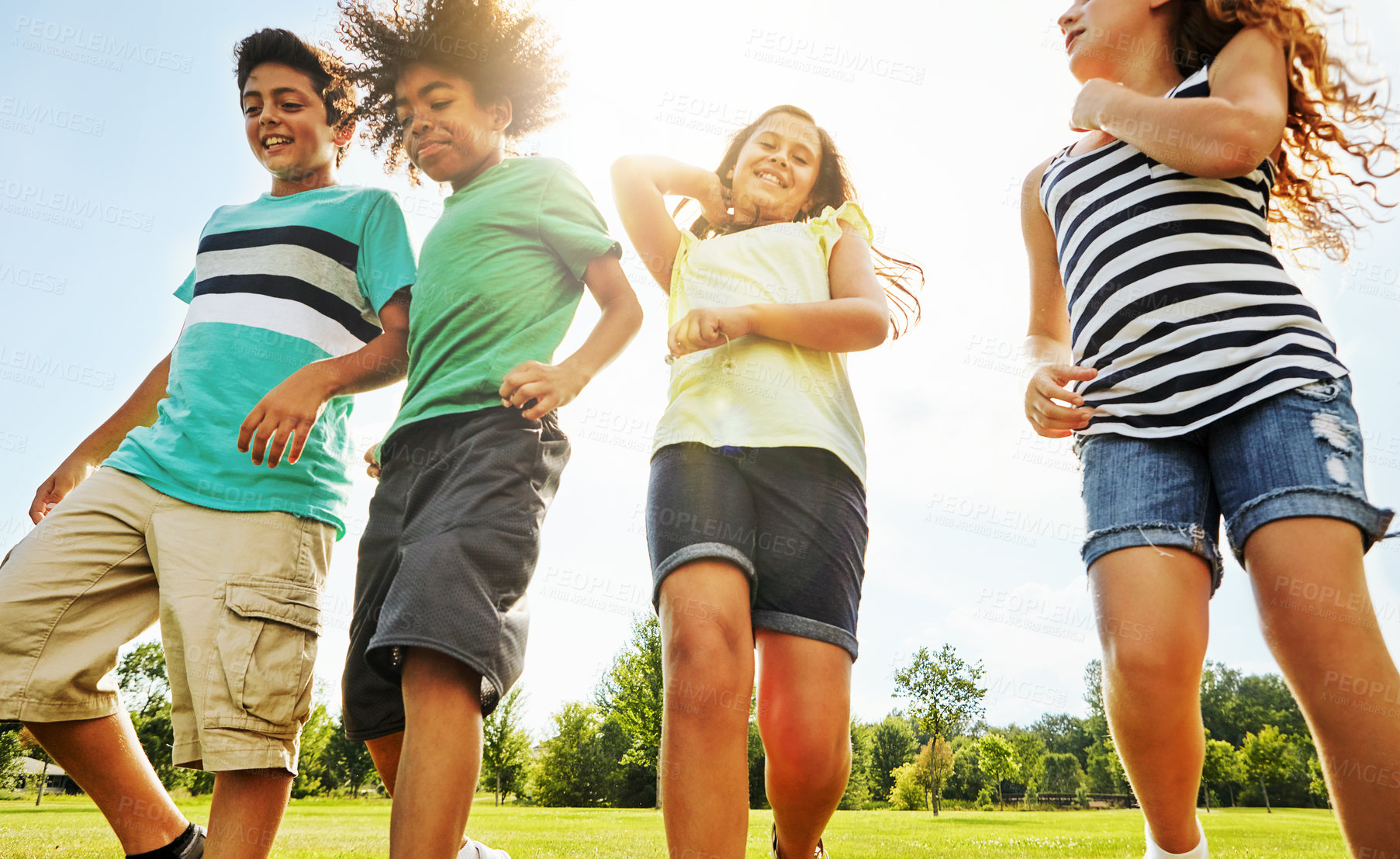 Buy stock photo Happy children, diversity and walking with youth in nature for fun, playful day or summer at park. Group of excited kids or friends enjoying sunny outdoor holiday or weekend on grass field together