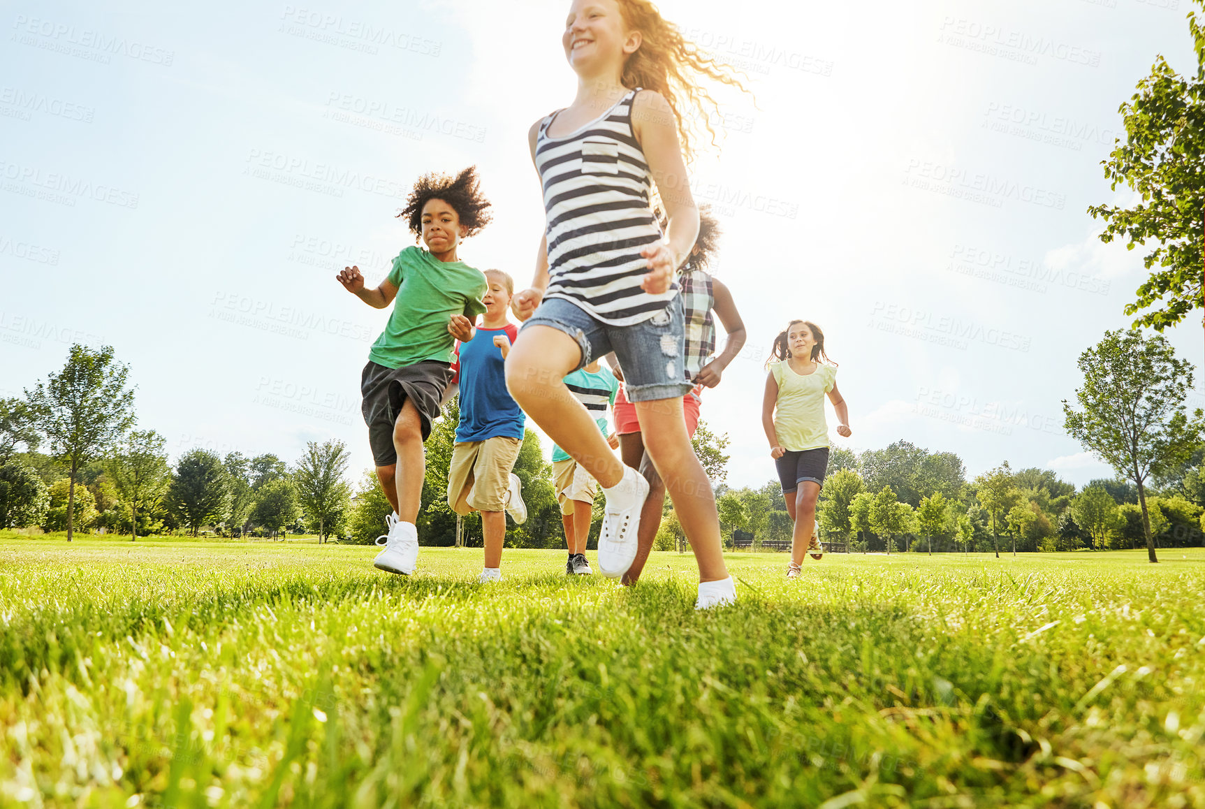 Buy stock photo Happy children, playing and running with friends in nature for fun, playful day or sunshine at park. Diversity or group of excited kids or youth enjoying sunny outdoor holiday on grass field together