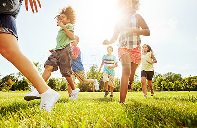 Buy stock photo Happy children, playing and running with grass field in nature for fun, playful day or sunshine at park. Diversity or group of excited kids or youth enjoying sunny outdoor holiday or weekend together