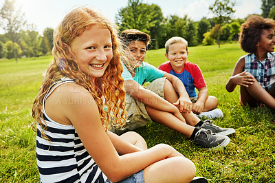 Buy stock photo Portrait of a group of diverse and happy kids sitting together on the grass outside