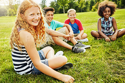 Buy stock photo Portrait of a group of diverse and happy kids sitting together on the grass outside