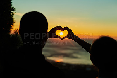 Buy stock photo Rearview shot of two young people making heart shapes with their hands