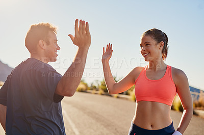 Buy stock photo Cropped shot of two young people high fiving during their workout