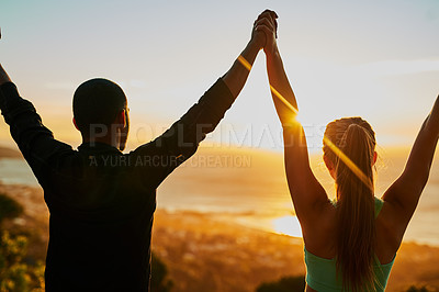 Buy stock photo Rearview shot of two young people standing with their arms raised during a workout