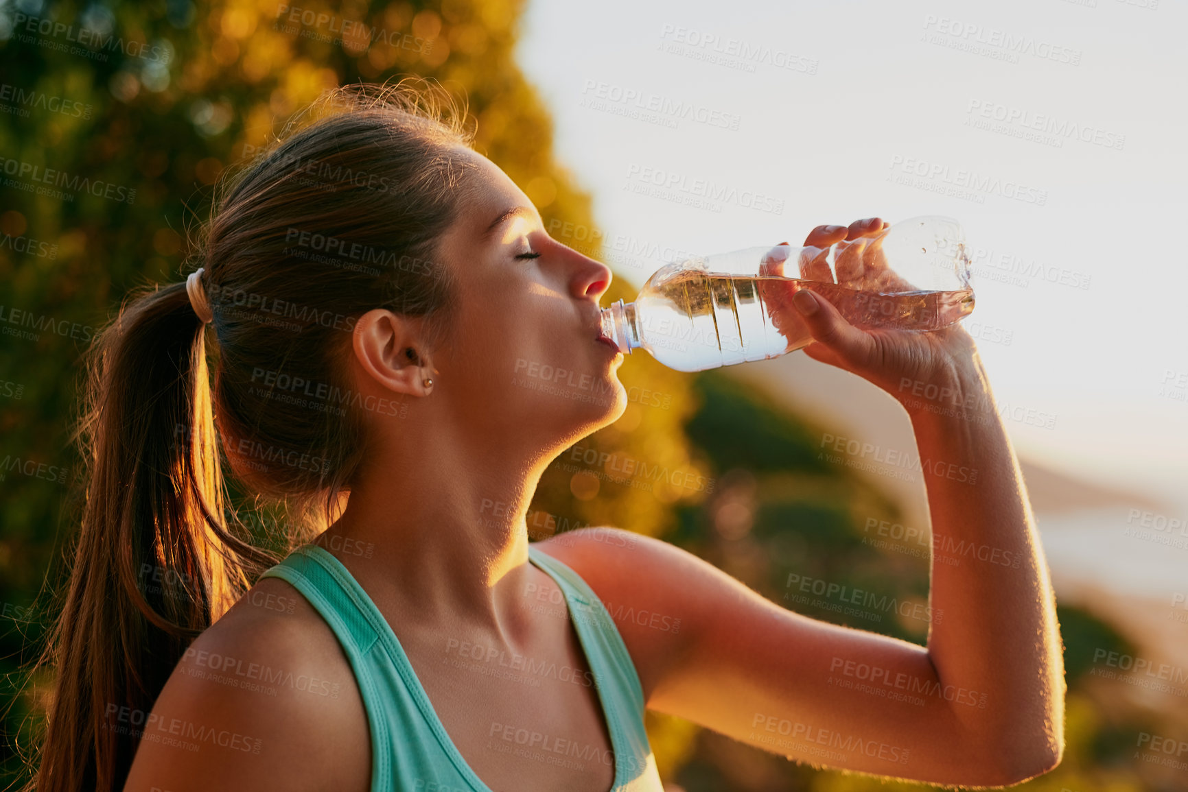 Buy stock photo Cropped shot of an attractive young woman getting a drink during her workout