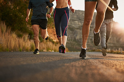Buy stock photo Shot of a fitness group running along a rural highway