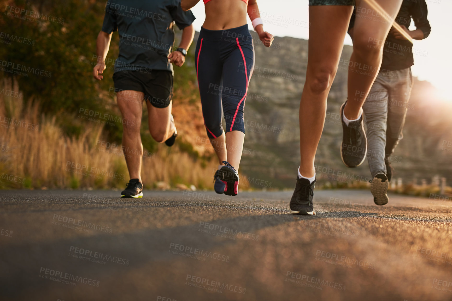Buy stock photo Shot of a fitness group running along a rural highway