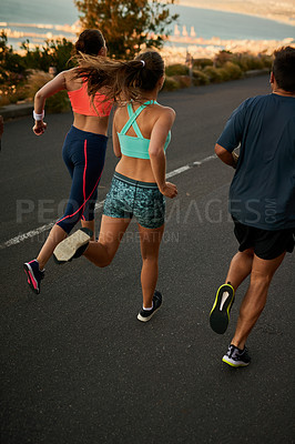 Buy stock photo Shot of a fitness group running along a rural highway