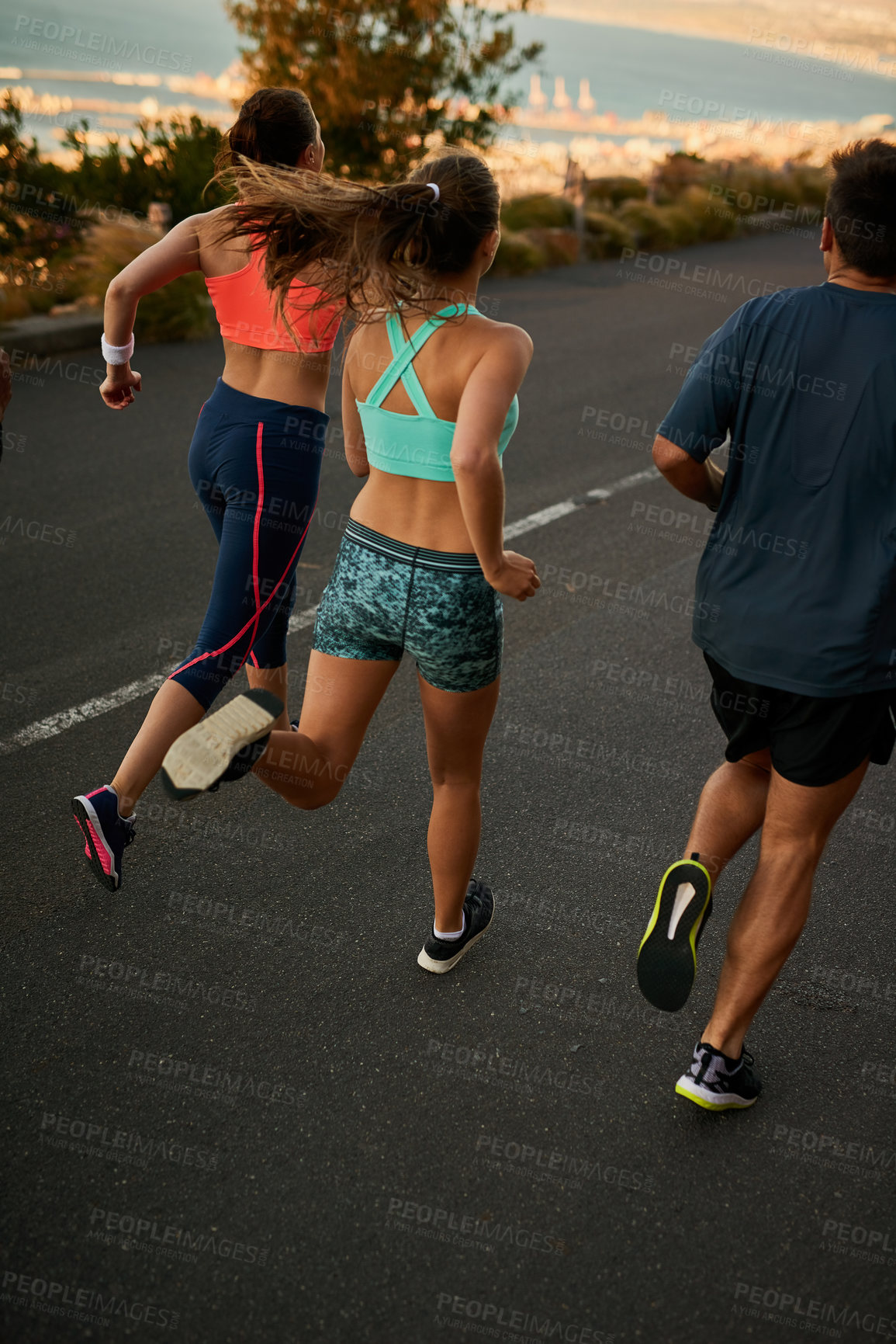 Buy stock photo Shot of a fitness group running along a rural highway