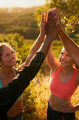 Buy stock photo Shot of a fitness group giving each other a high five as a team
