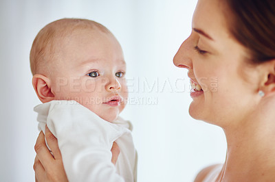 Buy stock photo A happy young mother hugging her cute baby boy at home and bonding while enjoying parenthood. Single parent being playful and affectionate, embracing precious moments with her newborn little child 