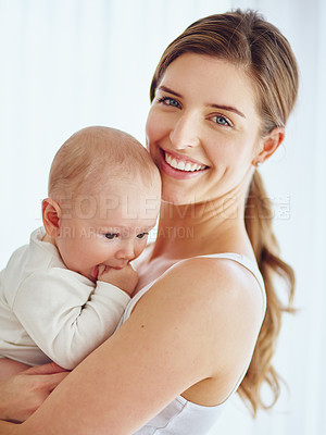 Buy stock photo Mother bonding with baby boy, smiling and enjoying family time in a room at home. Portrait of a happy, loving and caring single parent holding or carrying an adorable, cute and little newborn child