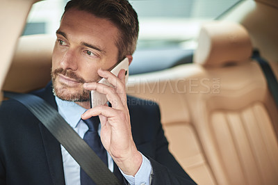 Buy stock photo Shot of a handsome businessman talking on his cellphone while driving into work