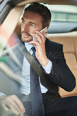 Buy stock photo Shot of a handsome businessman talking on his cellphone while driving into work