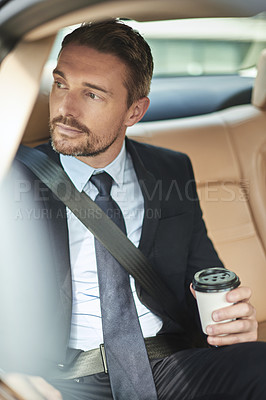 Buy stock photo Cropped shot of a handsome businessman drinking coffee while driving into work