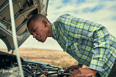 Buy stock photo Cropped shot of a young man checking under the hood of his car after breaking down