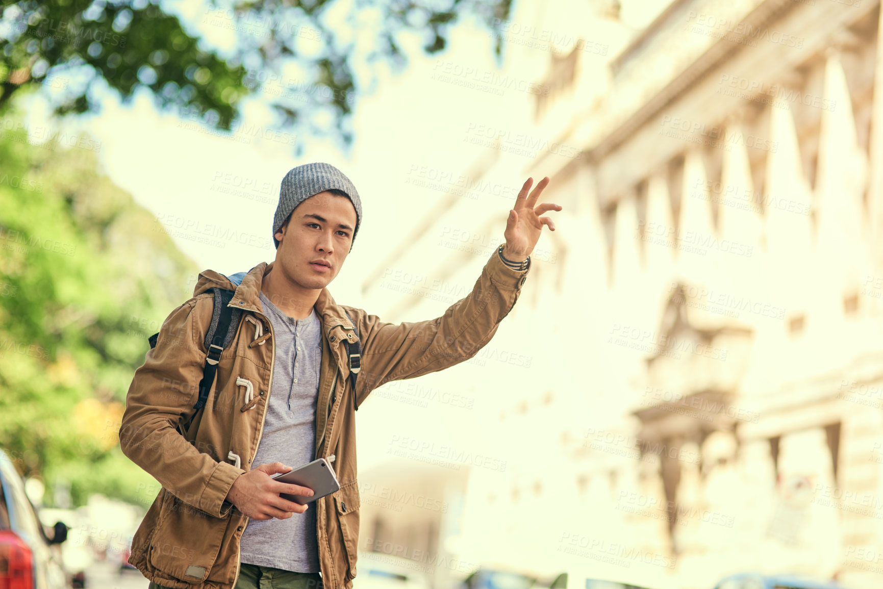 Buy stock photo Cropped shot of a young man gesturing to get a cab in the city