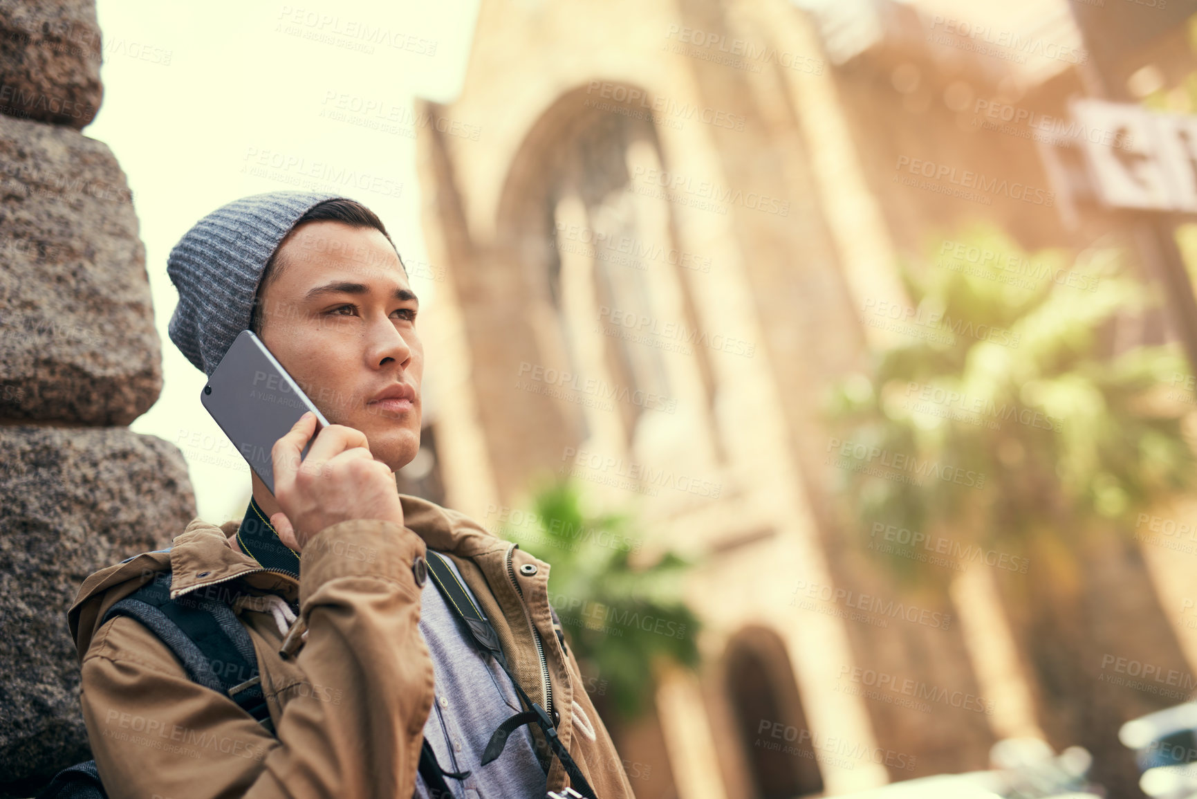 Buy stock photo Cropped shot of a young man talking on his cellphone while out in the city