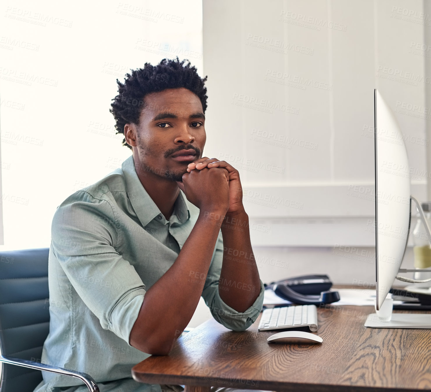 Buy stock photo Portrait of a confident young designer sitting at his desk in an office