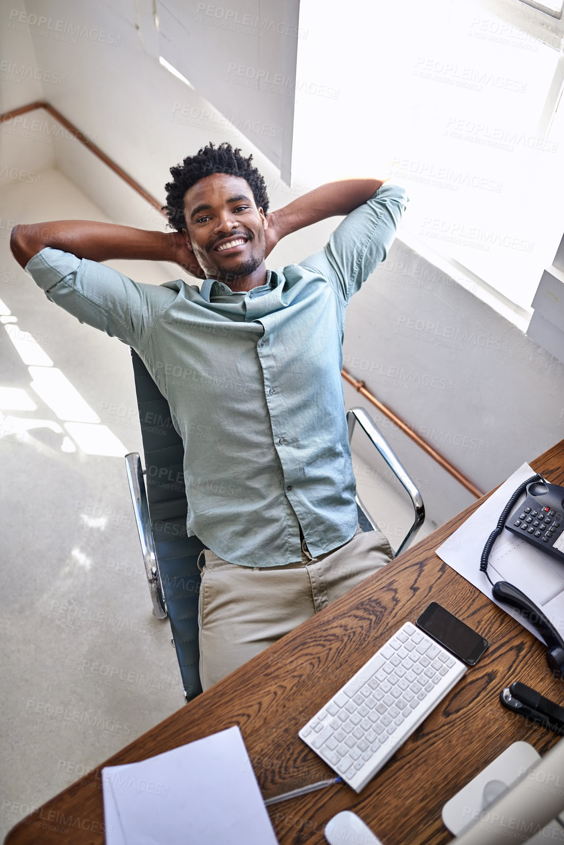 Buy stock photo Black man, portrait and relax with break above for completion, done or finished at office. Top view of young African or business employee sitting back in satisfaction or confidence for job success