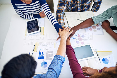 Buy stock photo High angle shot of a team of designers joining their hands together in unity