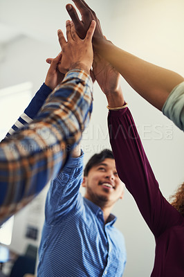 Buy stock photo Cropped shot shot of a team of designers high fiving together  in an office