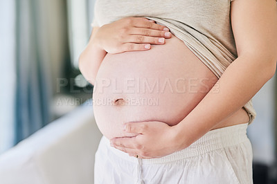 Buy stock photo Cropped shot of a woman holding her pregnant belly