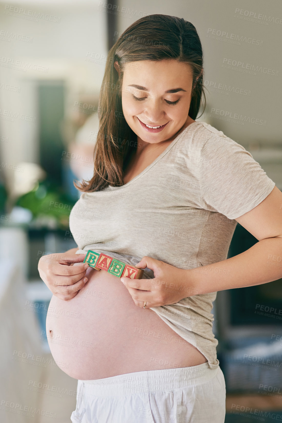 Buy stock photo Pregnancy, stomach and woman with baby blocks for maternity care, love and wellness in home. Family, parenting and happy pregnant person with wooden toys for child development, growth and health