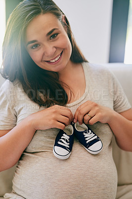 Buy stock photo Portrait, pregnant woman and shoes on belly in home for reveal of boy gender, journey and experience of pregnancy. Mother to be, holding sneakers and stomach for love or bonding and motherhood.