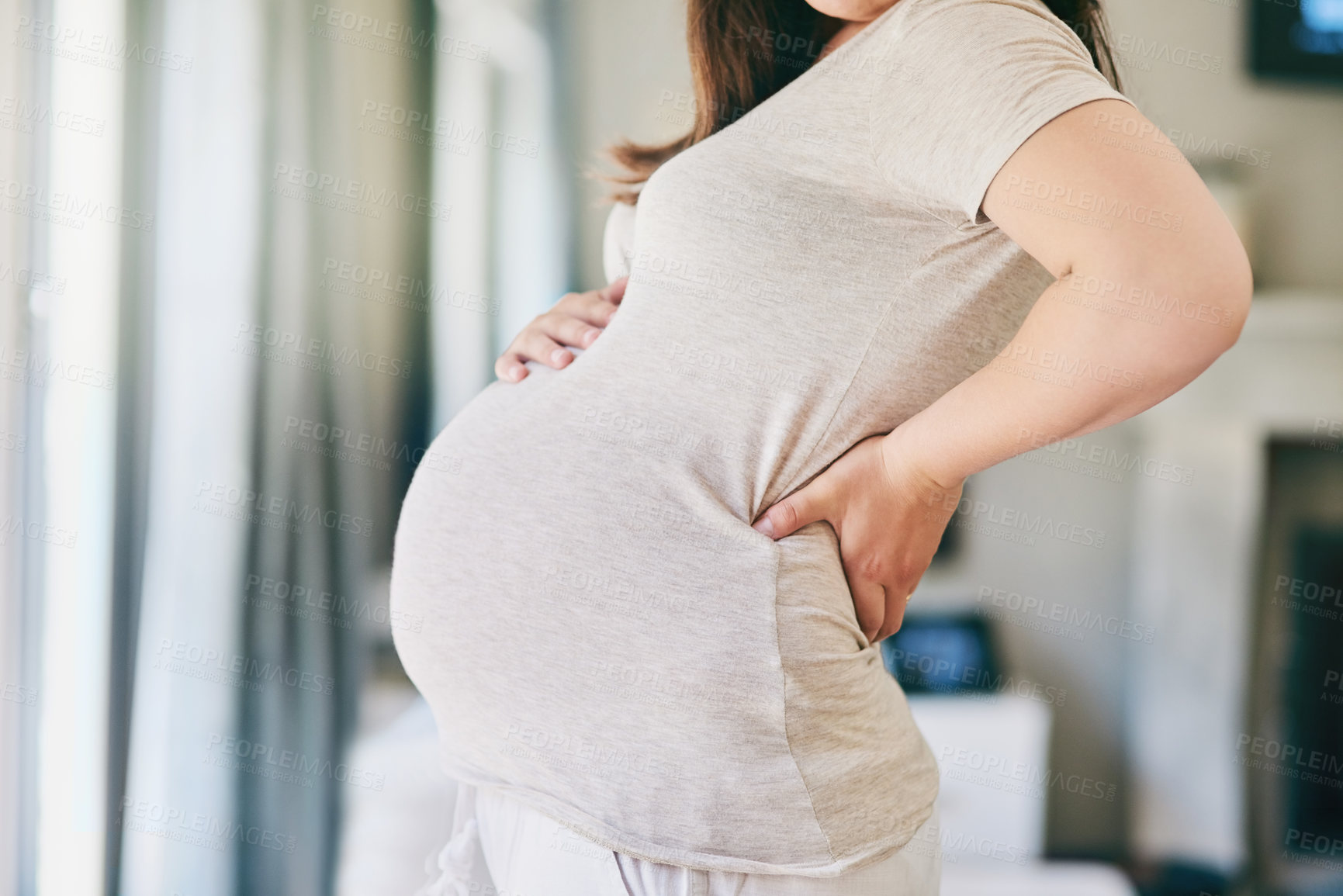 Buy stock photo Cropped shot of a young woman posing with her pregnant belly