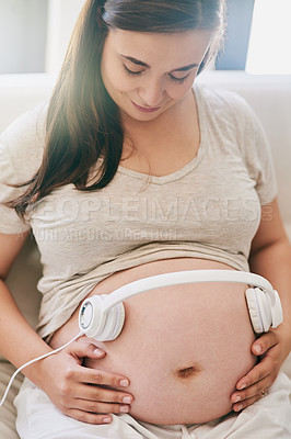 Buy stock photo Relax, couch and pregnant woman with headphones on stomach for child development in home. Pregnancy, growth and happy mom on sofa with audio, sound therapy and app for music streaming in living room