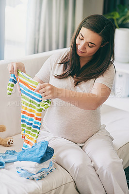 Buy stock photo Pregnant, woman and smile with clothes on sofa for newborn attire or apparel, folding and organizing for arrival of baby. Mother to be, vest and garments for wardrobe in home and ready for motherhood